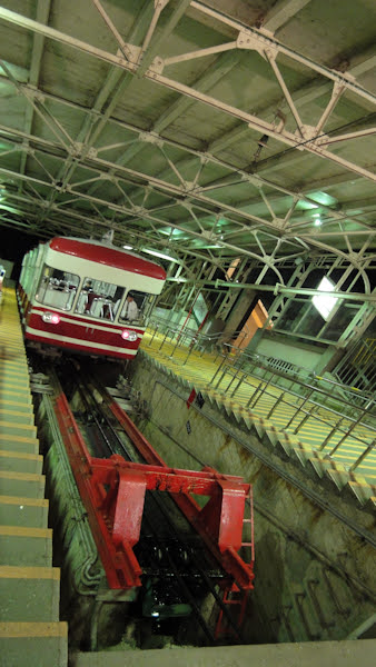 the funicular that takes you up has a red car and many stairs